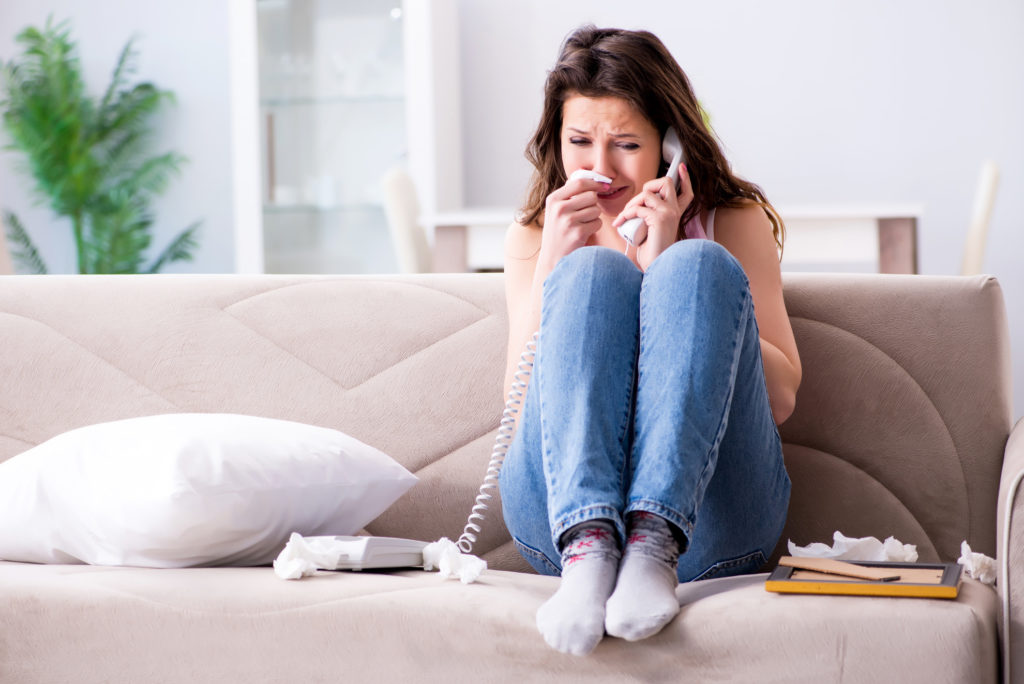 Woman crying on telephone with tissues